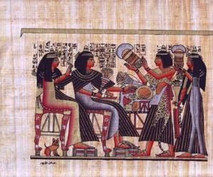 This view depicts one of the highest people and his wife. They are shown here sitting on chairs and receiving jewels and flowers from two maids. There is a cat under the wife chair. This scene was taken from the 19th Dynasty.